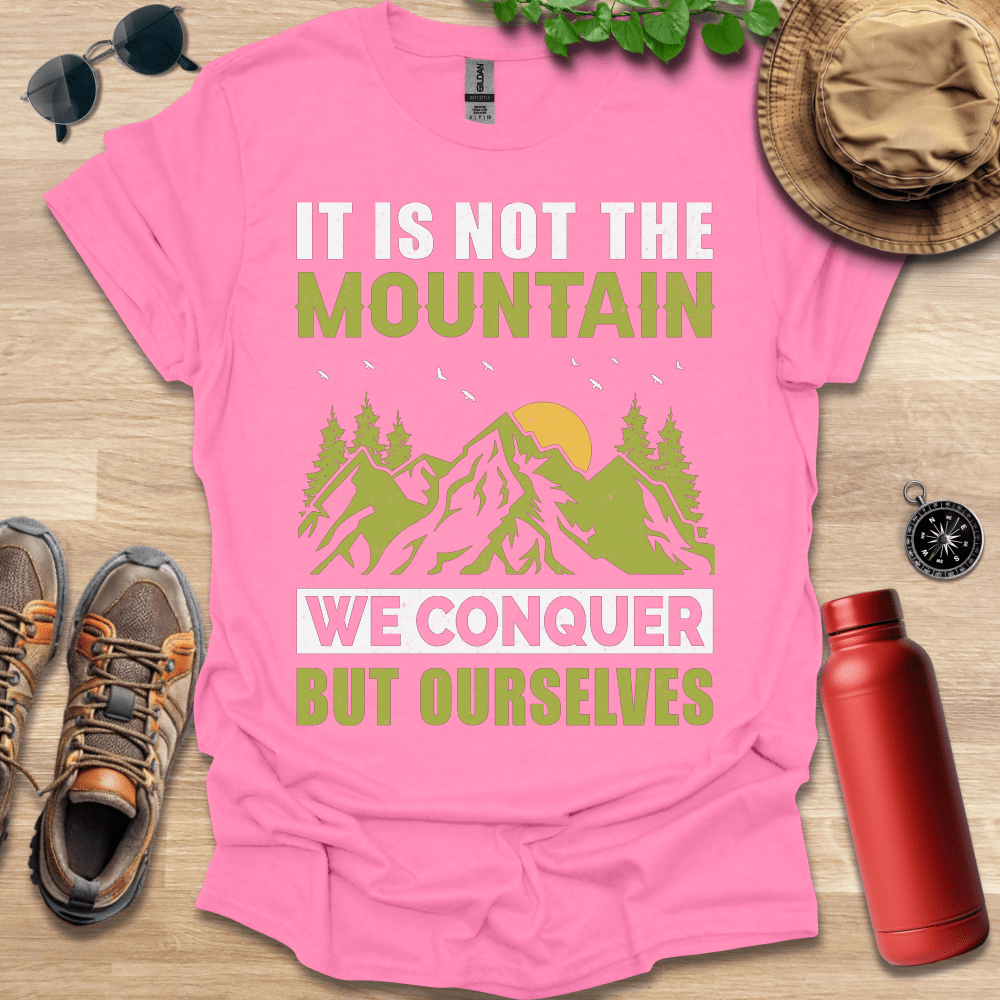 a pink shirt that says it is not the mountain we conquer but ourselves